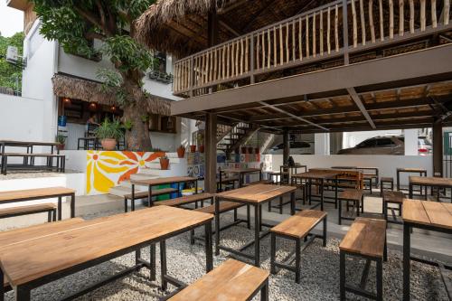a group of tables and benches in a restaurant at The Circle Hostel, La Union in San Fernando