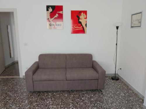 a brown couch in a living room with a poster at Casa Nastro in Giovinazzo