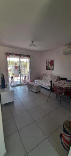 - un salon avec un lit et du carrelage dans l'établissement Résidences du Monde, à Moriani-Plage