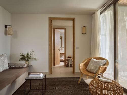 a living room with a couch and a chair at Eagles Villas - Small Luxury Hotels of The World in Ouranoupoli