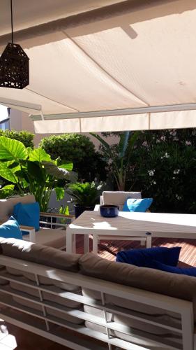 d'une terrasse avec une table blanche et un canapé. dans l'établissement La TAMARISSIME, à La Seyne-sur-Mer