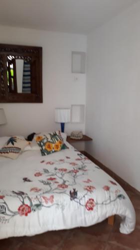 une chambre avec un lit avec un couvre-lit fleuri dans l'établissement La TAMARISSIME, à La Seyne-sur-Mer