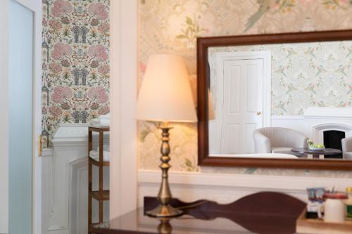 a lamp sitting on a table in front of a mirror at The Atholl Palace in Pitlochry
