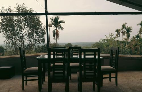 tavolo e sedie con vista su una palma di kaffee valley - Kurumbalakotta a Padinjarathara