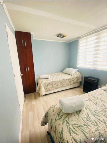 a bedroom with two beds and a window at Departamento céntrico los andes chile in Los Andes