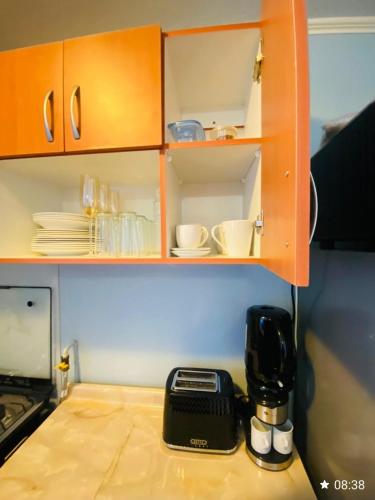 a kitchen counter top with a coffee maker and cups at Departamento céntrico los andes chile in Los Andes