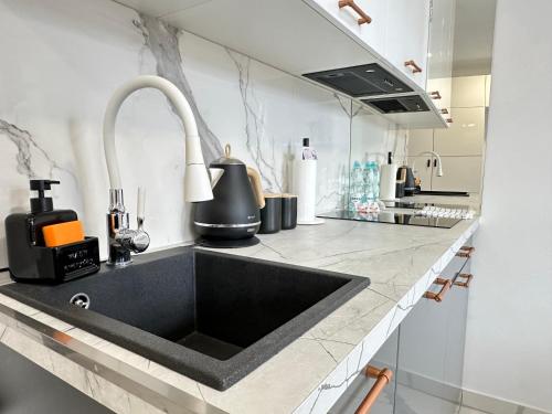 a kitchen with a black sink and a counter at MOVEEN! Wynajem apartamentów we Wrocławiu! 10 minut od centrum in Wrocław