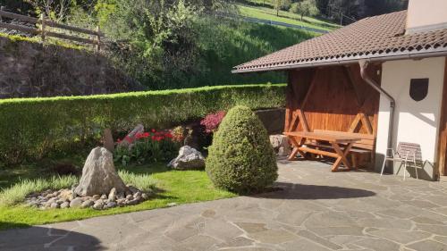 a garden with a bench next to a house at Mitterhofer in Villandro