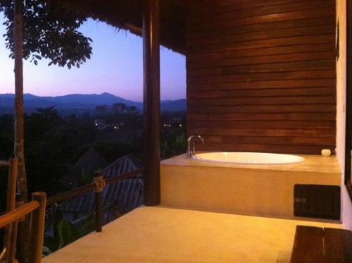 a bathroom with a tub on a balcony with a view at Chang Pai Hill in Pai