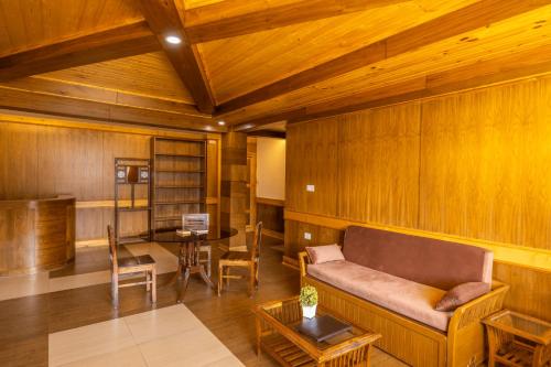 a living room with a couch and a table at Vivaan The Sunrise in Manāli