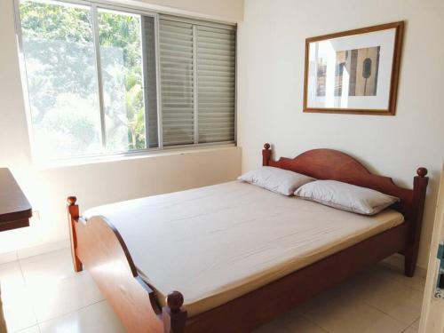 a bed in a room with a large window at Ap com sacada à beira mar Praia mansa in Matinhos