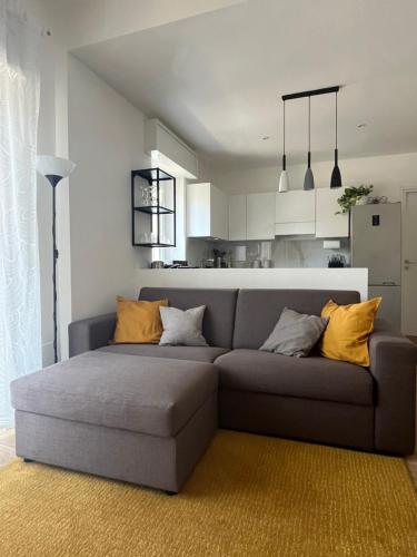 ein Wohnzimmer mit einem grauen Sofa und gelben Kissen in der Unterkunft Casetta Diana in Lido di Ostia