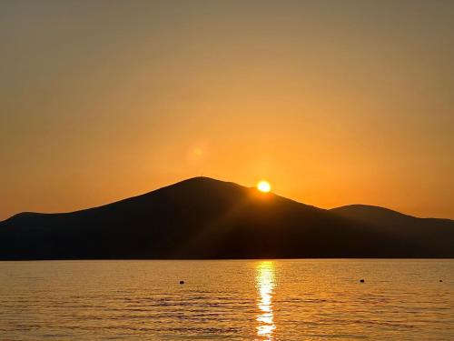 a sunset over a mountain in front of a body of water at George’s Apartment in Orikum