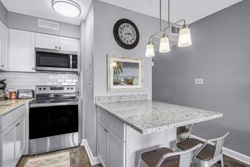 a kitchen with a counter and a clock on the wall at Condo with Breathtaking Views in Murrells Inlet in Myrtle Beach