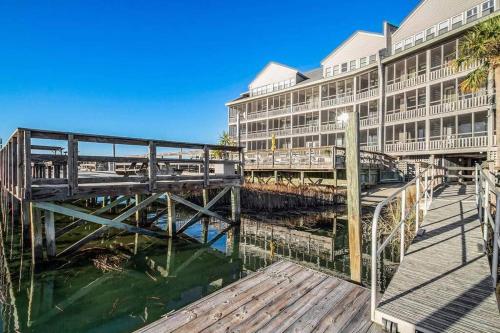 a bridge over the water in front of a building at Condo with Breathtaking Views in Murrells Inlet in Myrtle Beach