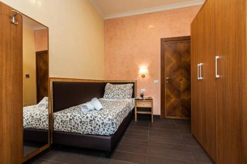 a small bedroom with a bed and a mirror at Guest's Heaven in Rome