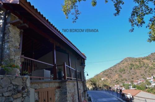 a building with a balcony with a mountain in the background at To Kastri in Kalopanayiotis