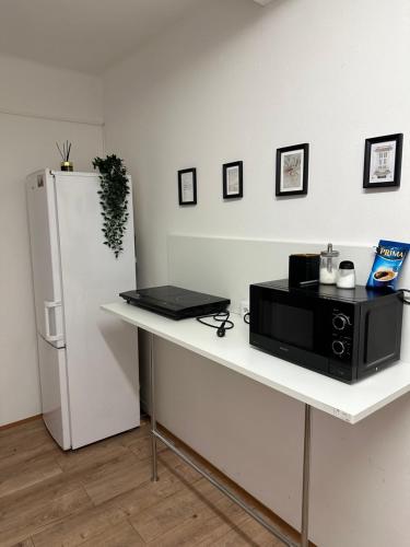 a white table with a microwave and a refrigerator at Nice rooms in City Center Kraków in Kraków