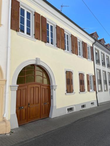 a white building with a brown door and windows at Holländers Apartment in Bruchsal