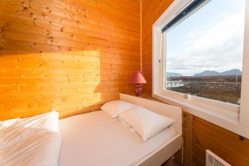 a small room with a bed and a window at Statsbuene i Kabelvåg in Kabelvåg