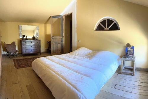 - une chambre avec un grand lit blanc et une commode dans l'établissement Dépendance Valensole, à Valensole