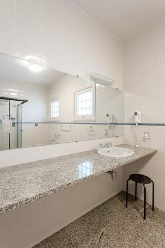 a bathroom with a sink and a large mirror at Sítio da malva in Sorocaba