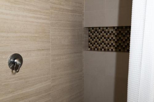 a shower with a glass door with a tile at Infinity Suites single room 104 in Cancún