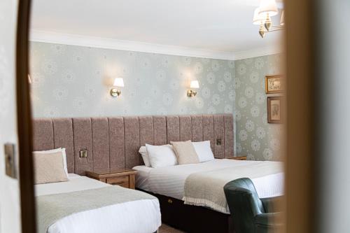 a hotel room with two beds and a mirror at The Atholl Palace in Pitlochry