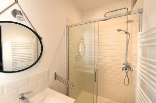 a bathroom with a glass shower and a mirror at Le Havre De Paix in Le Perrey