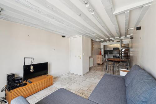 un salon avec un canapé et une télévision dans l'établissement Orsay Invalides - Lille 1bdr by B'Your Home, à Paris