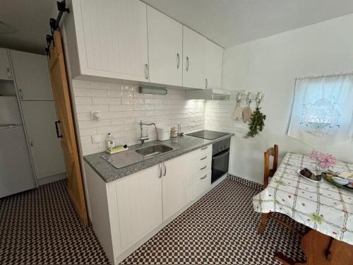 a small kitchen with a sink and a stove at Lugar das Andorinhas in Albufeira