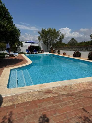 a large swimming pool with blue water at Lugar das Andorinhas in Albufeira