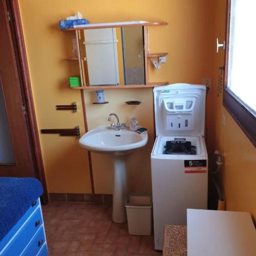 une petite cuisine avec un évier et une cuisinière dans l'établissement Maison Tregastel Saint-Anne, à Trégastel-Plage