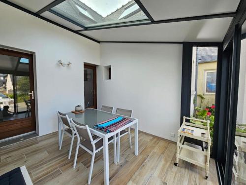 une salle à manger avec une table et des chaises en verre dans l'établissement Maison Tregastel Saint-Anne, à Trégastel-Plage