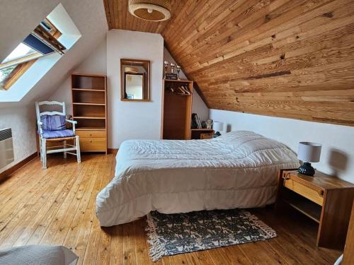 une chambre avec un lit et un plafond en bois dans l'établissement Maison Tregastel Saint-Anne, à Trégastel-Plage