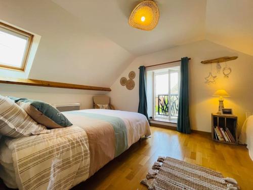 une chambre avec un grand lit et une fenêtre dans l'établissement JolyHome, prestations de qualité entre Terre et Mer, à Maupertus-sur-Mer