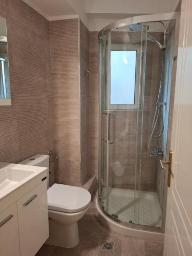 a bathroom with a toilet and a glass shower at Sandy's house in Ioannina