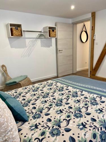 une chambre avec un lit avec une couverture bleue et blanche dans l'établissement «Au Renard»,proche d’Europa-Park,Strasbourg,Colmar, à Herbsheim