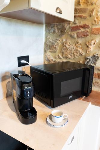 a coffee maker and a cup of coffee on a counter at Borgo Campassini in Monteriggioni