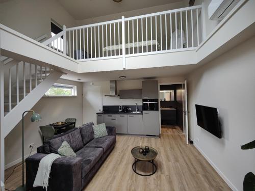 a living room with a couch and a staircase at B&B de Gouden Ploeg met Jacuzzi in Bergentheim