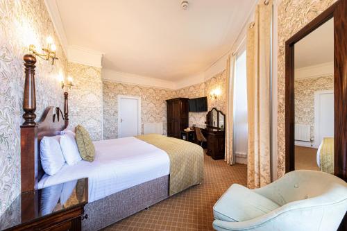 a hotel room with a bed and a chair at The Atholl Palace in Pitlochry