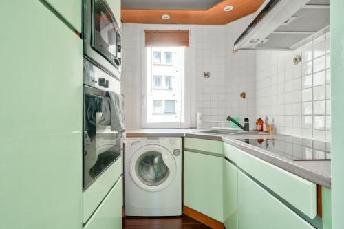 une cuisine avec une machine à laver et un évier dans l'établissement Charmant studio - Paris Boulogne Marcel Sembat, à Boulogne-Billancourt