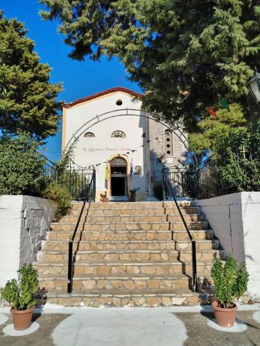 a church with stairs in front of a building at George & Dimitra's House in Kharokopión