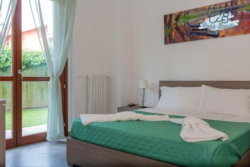a bedroom with a bed with green sheets and a window at Casa Bonita Rho in Rho