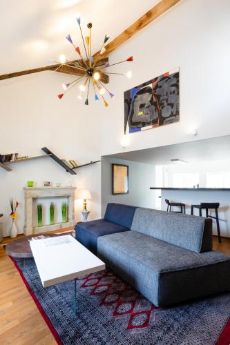 a living room with a blue couch and a chandelier at LAGO WELCOME PALAIS in Luxembourg