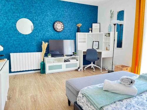 une chambre avec un lit, une télévision et un bureau dans l'établissement Spacieux studio - Au pied de la gare Cergy-le-Haut, à Cergy