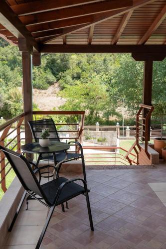 a patio with two chairs and a table on a porch at Villa Anastasia 2 in Fourka