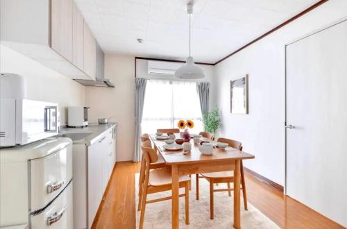 a kitchen with a table and chairs in a kitchen at MUJIroomTaisyoOsaka in Osaka
