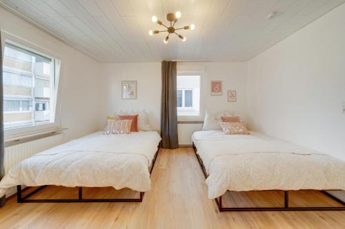 two beds in a white room with a ceiling at Stuttgart am Wasen Toplage 4Zi 80qm in Stuttgart