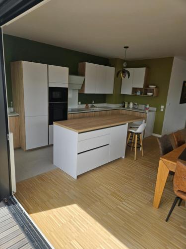 une cuisine avec des armoires blanches et une table et des chaises dans l'établissement La Varenne Standing, à Chennevières-sur-Marne